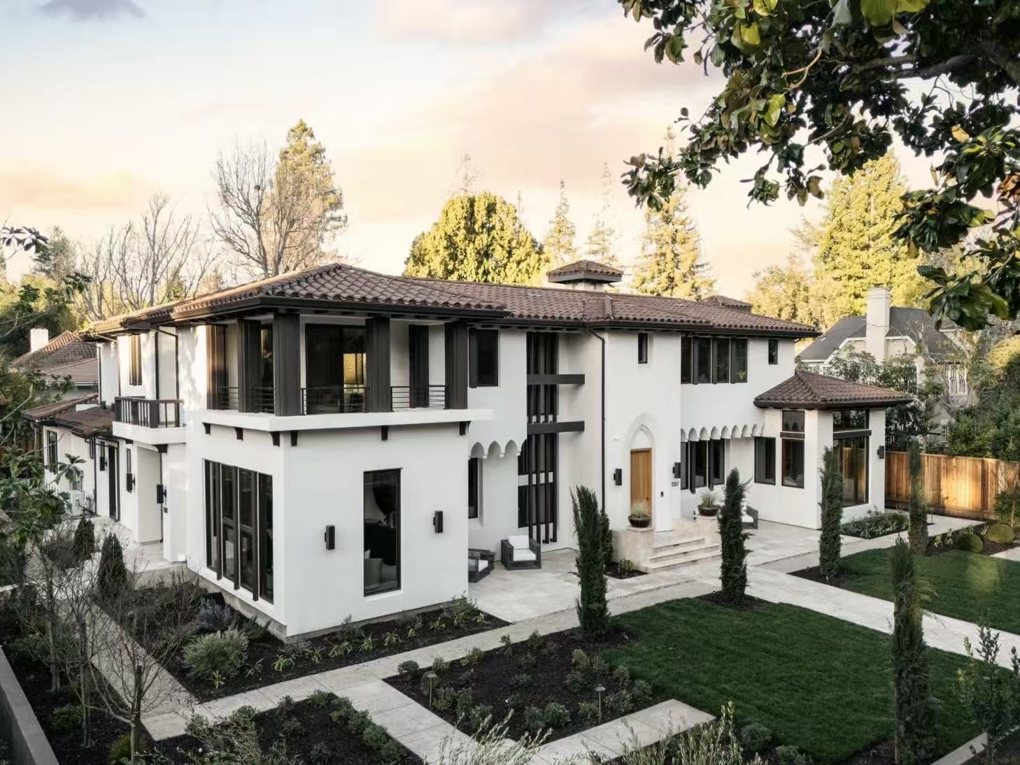 Exterior view of the San Jose residence with white stucco facade, black-framed windows, and landscaped lawn