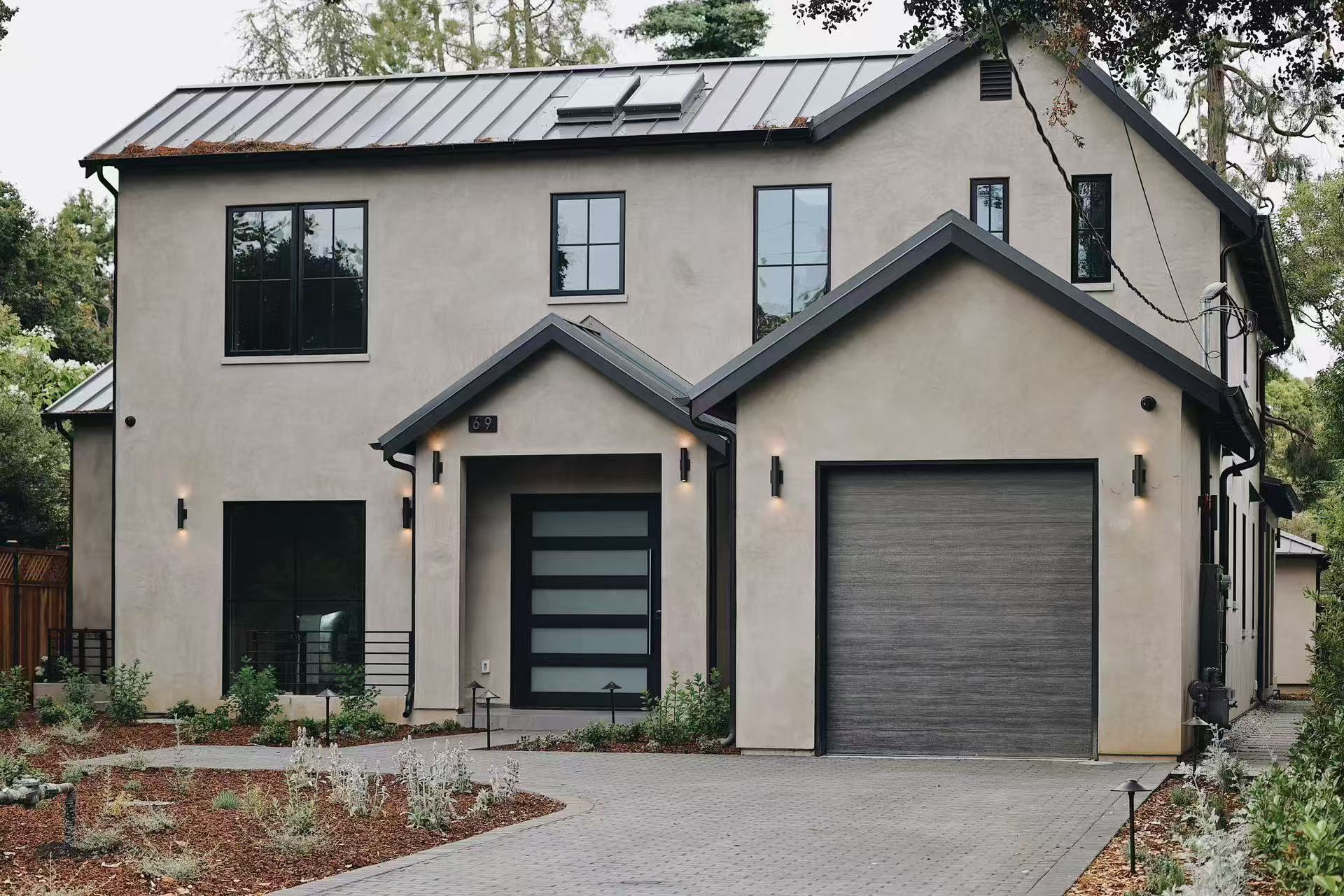 Front elevation of the contemporary residence with black-framed openings and integrated garage