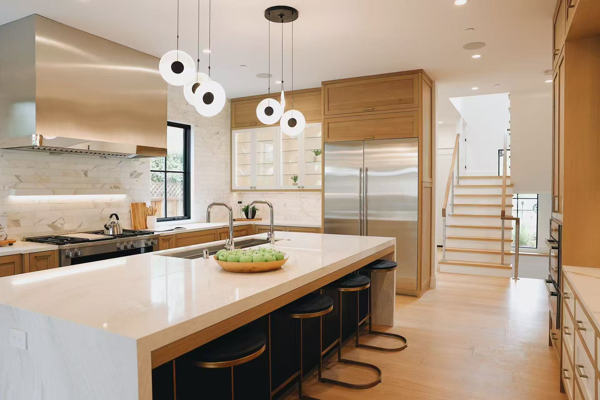 Wide view of the warm timber kitchen with central island, stainless steel appliances, and pendant lighting