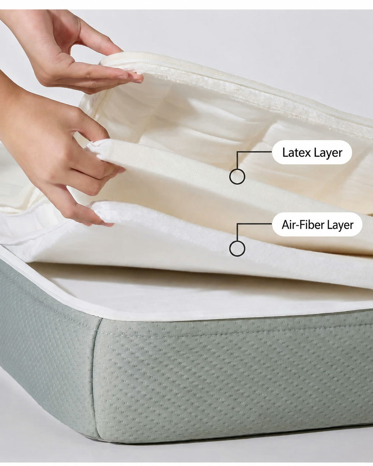  Hands separating the latex layer and air-fiber layer inside the open mattress cover