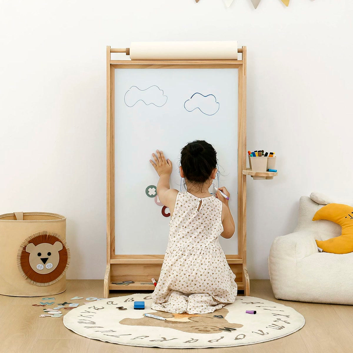 Child drawing at a natural pine paper-roll easel