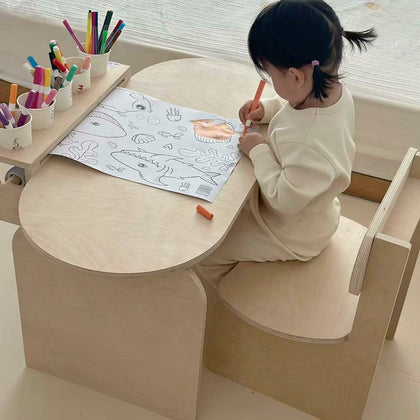  Elevated view of a child drawing on paper at the plywood desk
