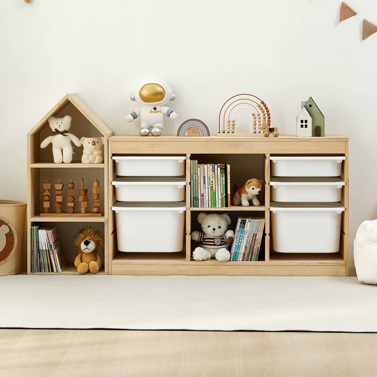Pine house bookcase beside a low three-column cabinet with white pull-out bins