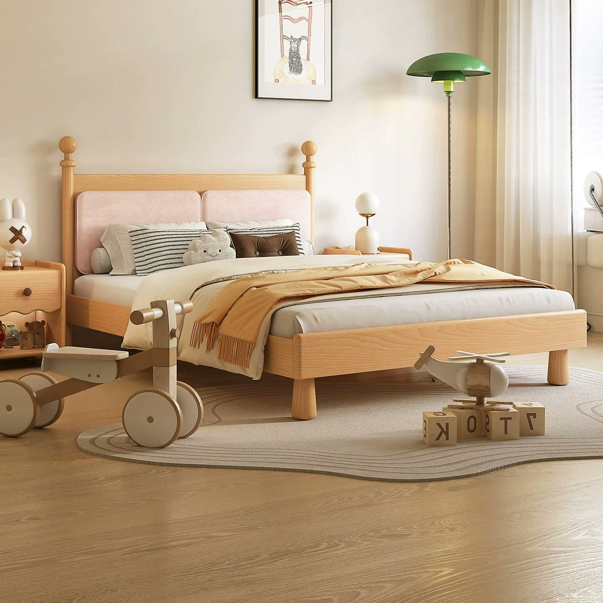 Natural birch bed with pink cushioned headboard and rounded wooden finials