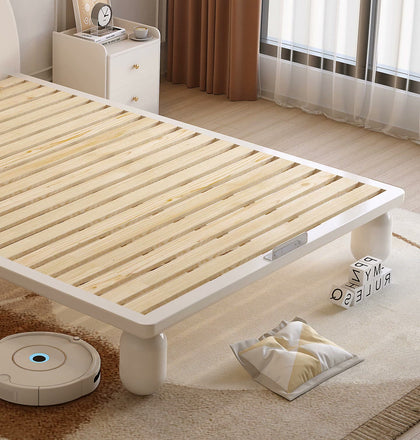 Exposed horizontal wood slats, cream frame and foot-end retainer.