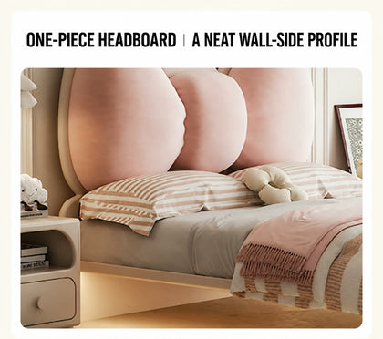  Side view of the pink padded bow within its one-piece wood headboard.