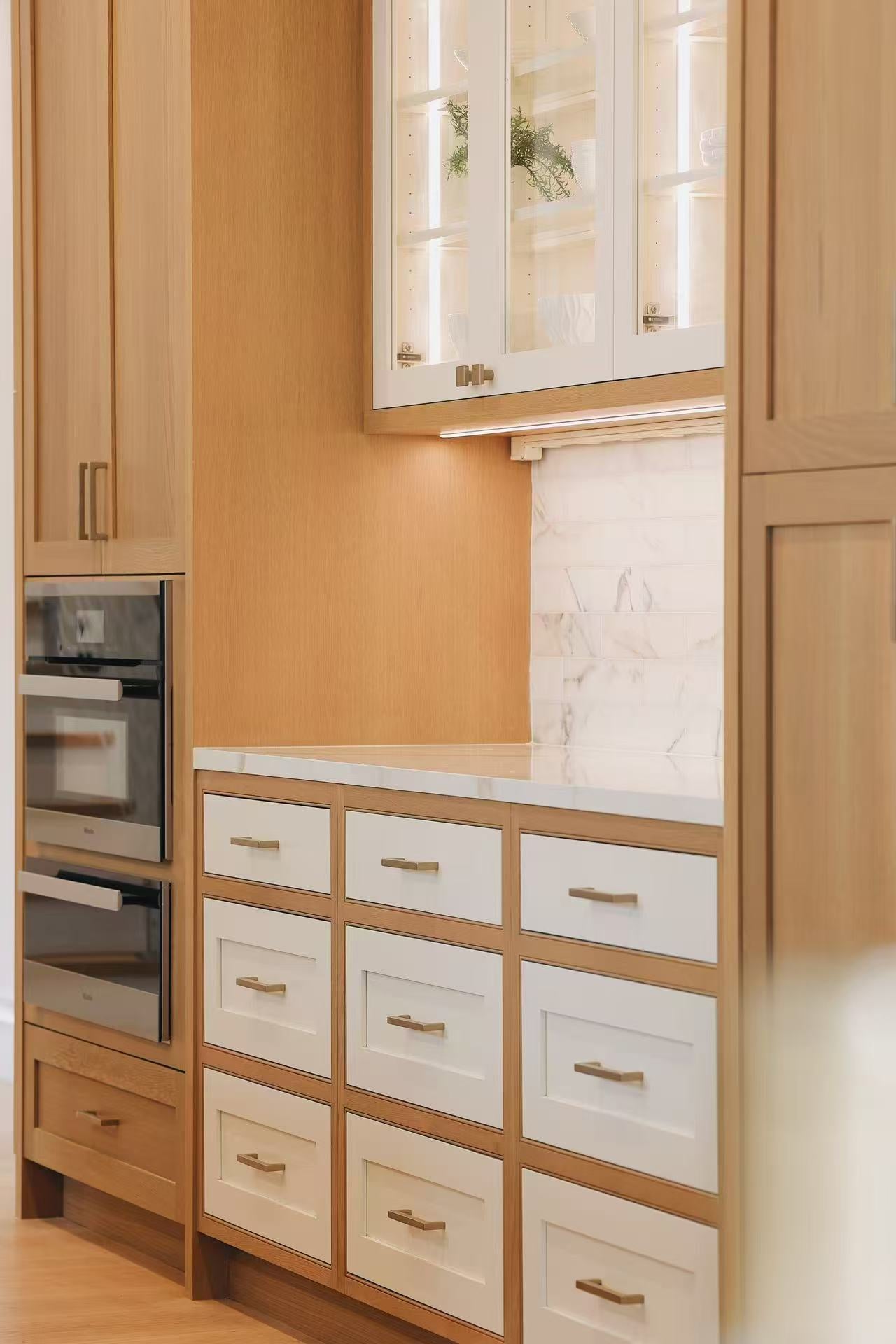 Detail of lower drawers, glass display cabinet, and marble-effect backsplash