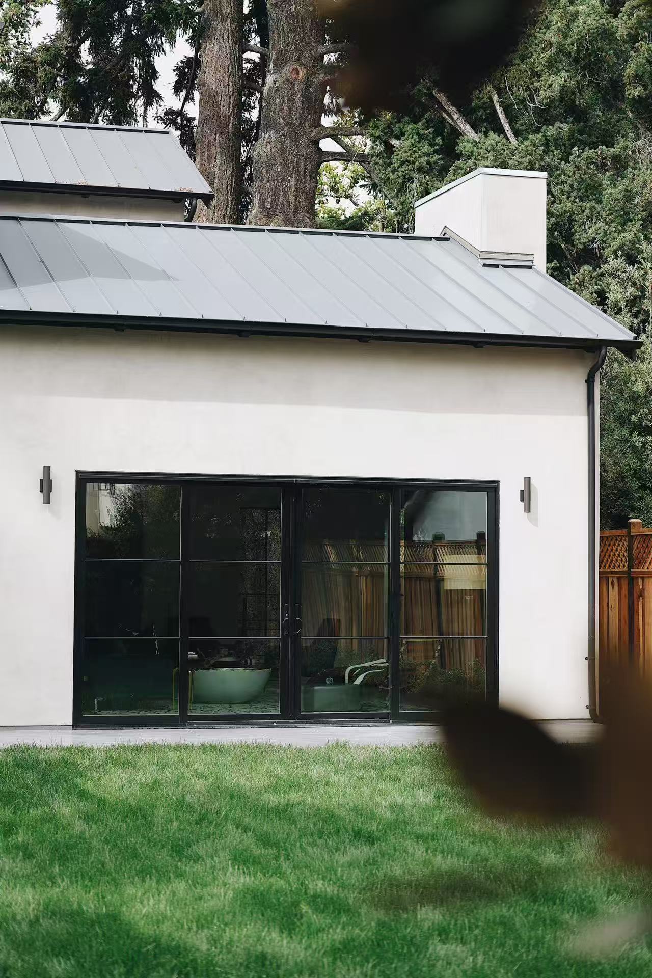 Rear facade with lawn and large black-framed window