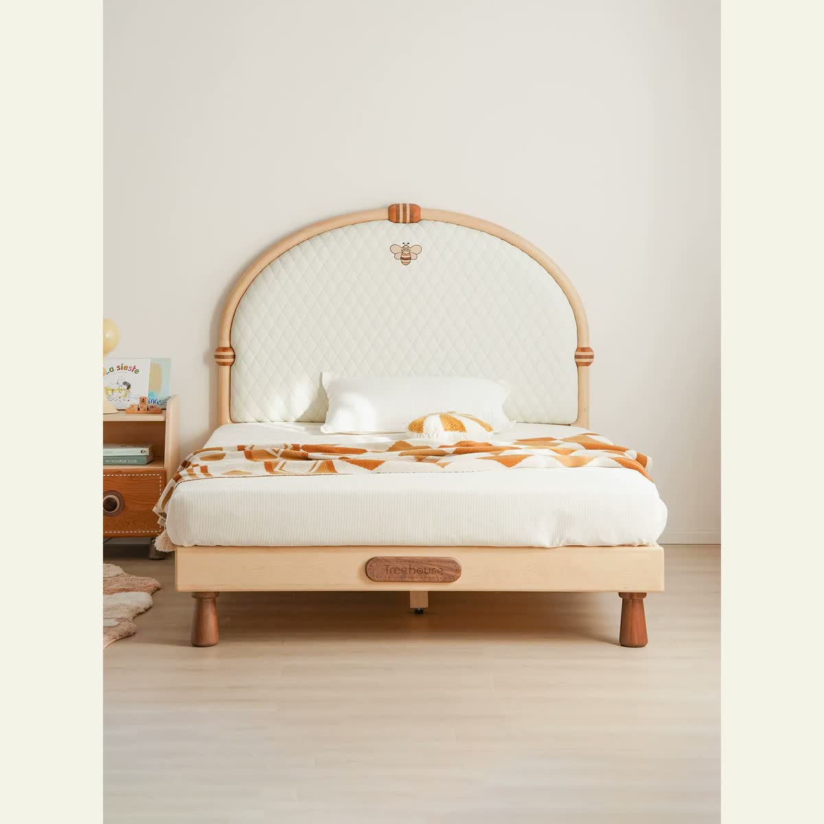 Front view of the bee-motif upholstered wood bed