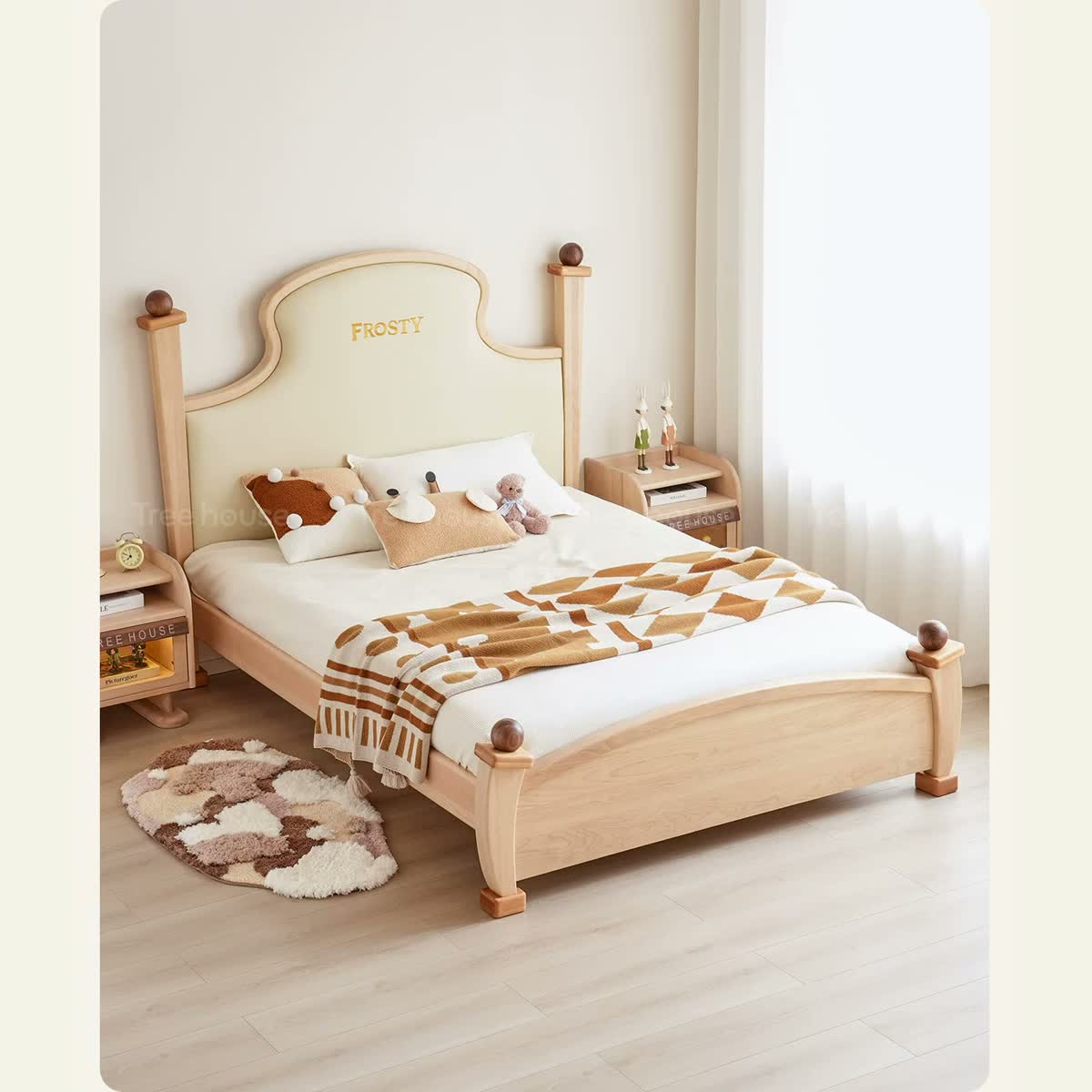 Light Windsor bed with cream upholstered headboard and curved wood footboard.