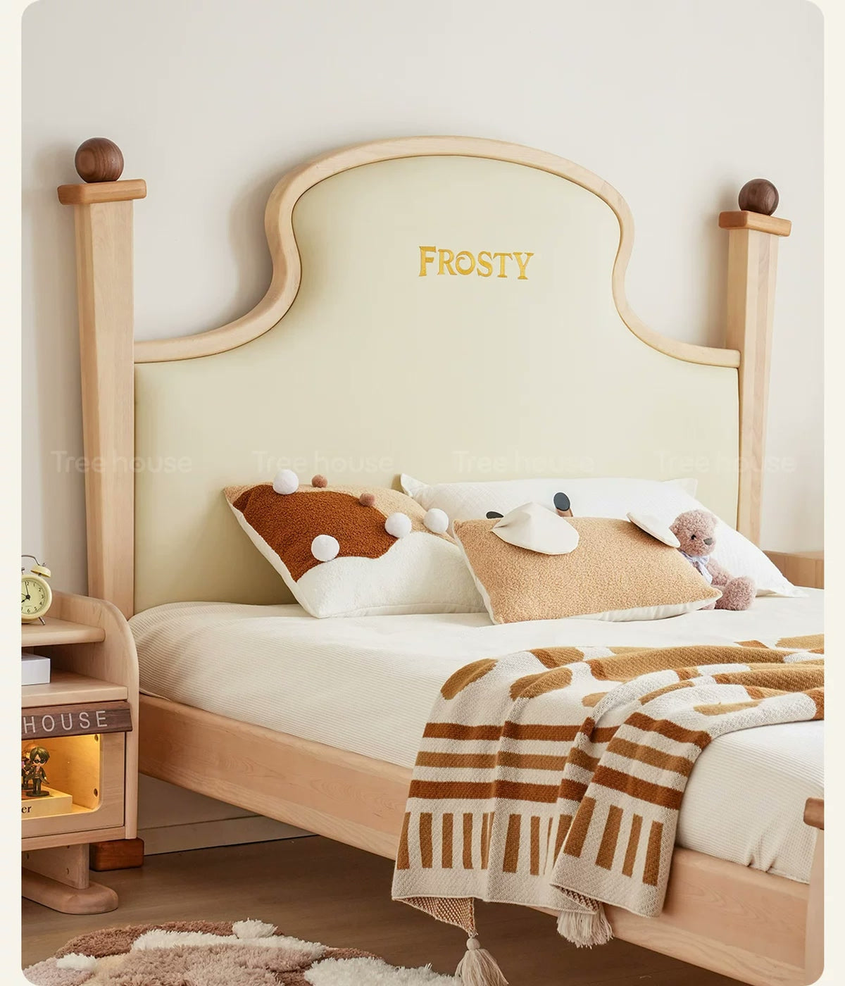  Shaped cream upholstered headboard framed in light wood.
