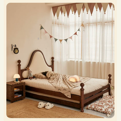  Vintage dark wood bed with a cream cloud-shaped upholstered headboard