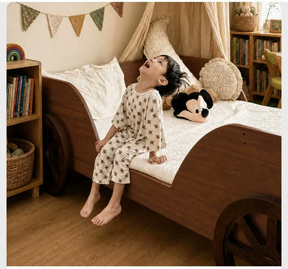  Child seated at the low side opening of the wood car bed.
