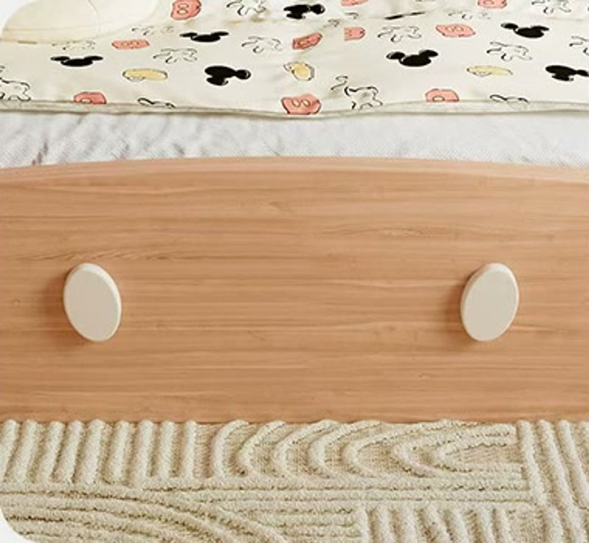  Curved wood footboard with two cream circular accents.