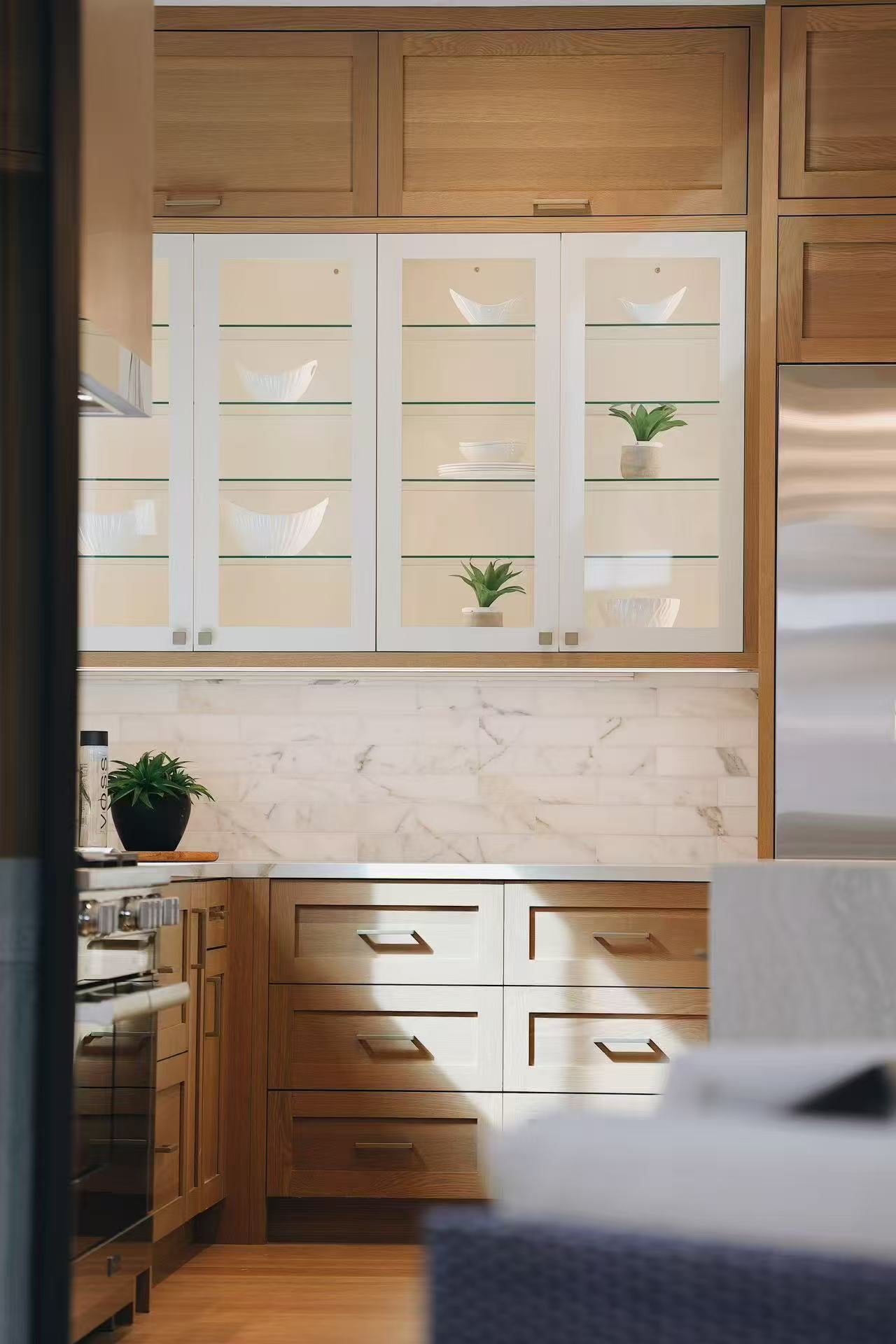 Display wall with timber cabinetry, glass doors, and softly lit shelves
