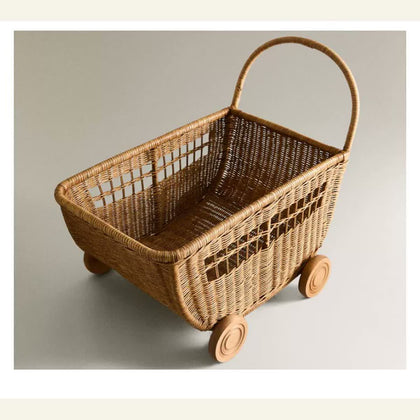  Empty vintage-brown rattan storage trolley with curved handle and round wheels.
