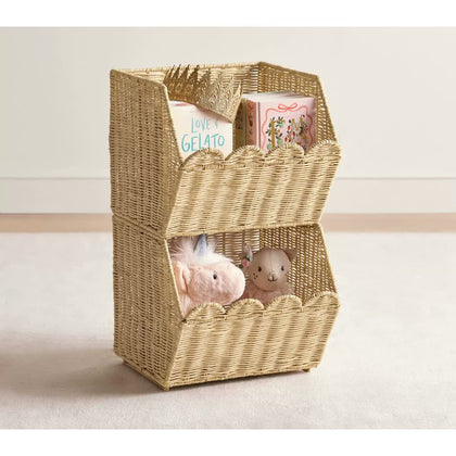  Two stacked scalloped rattan baskets holding books and soft toys.