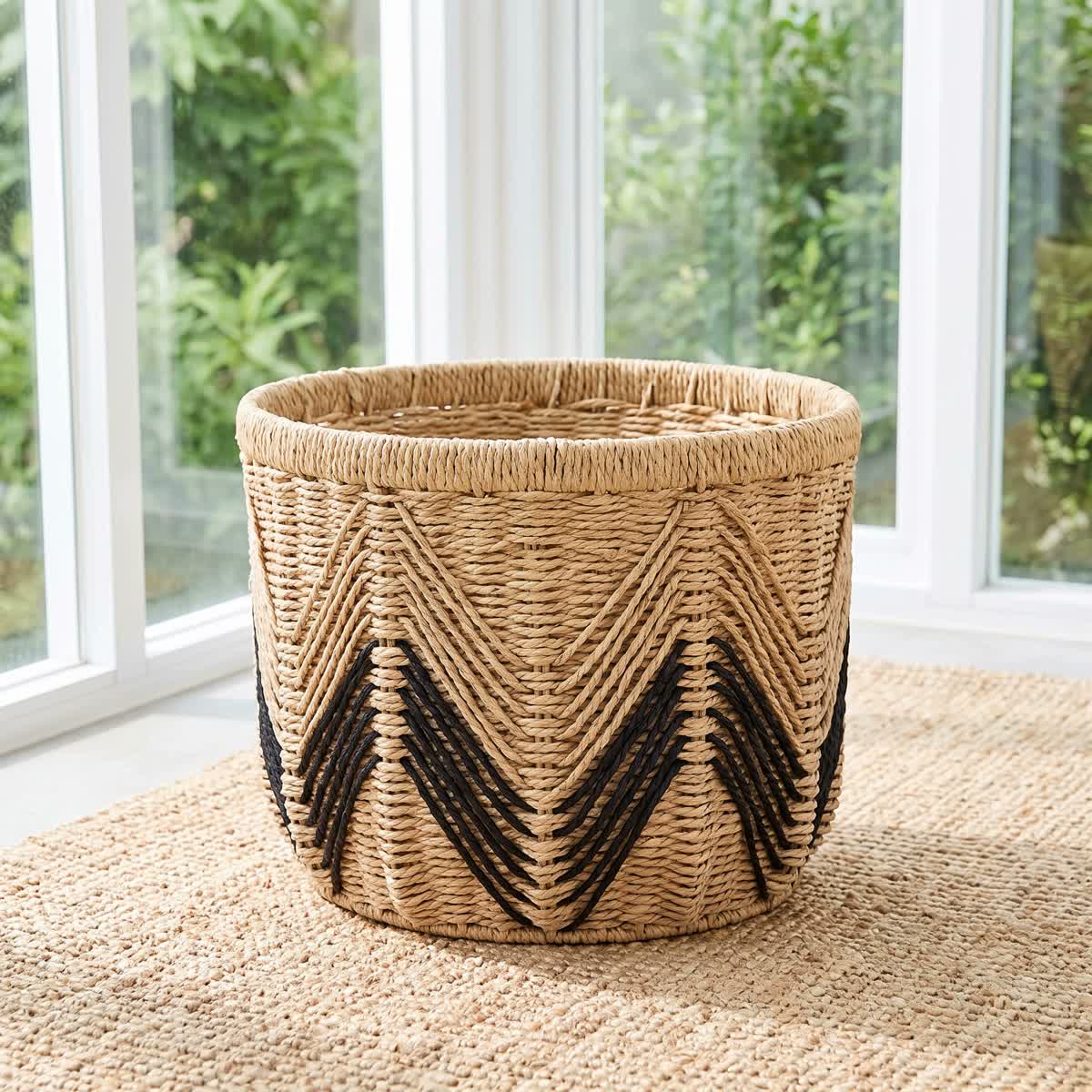 Natural-toned woven basket with a black chevron pattern beside a window.