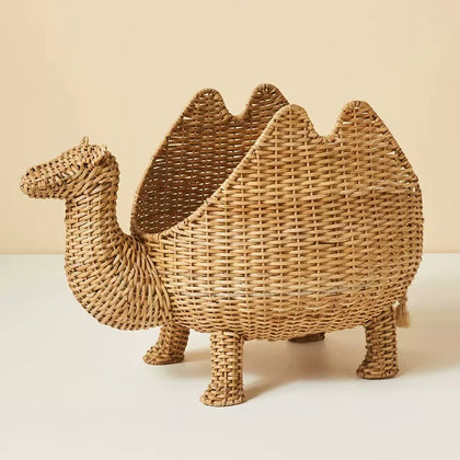  Natural rattan camel-shaped basket with hump-shaped sides and four woven legs.
