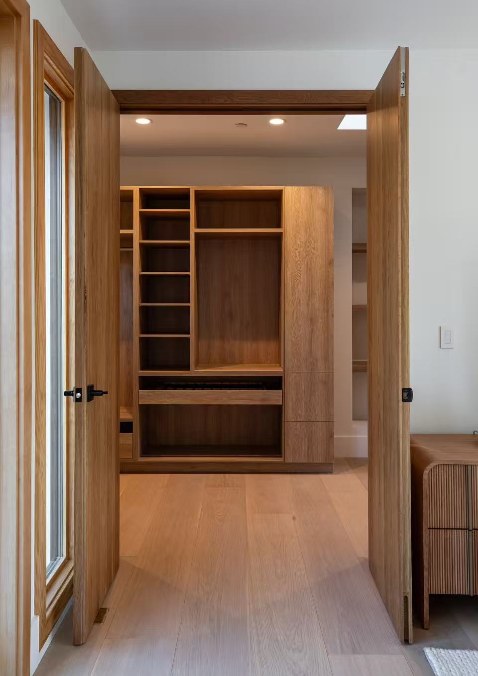 Interior hallway with warm timber door and pale flooring