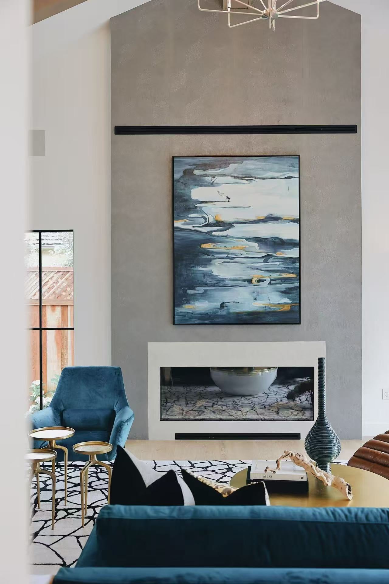 Living room with textured grey fireplace wall and blue seating