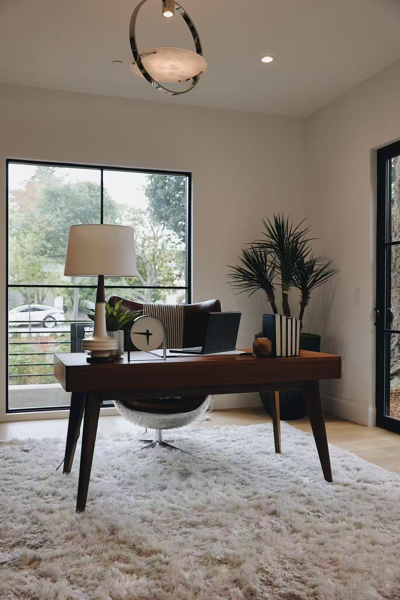 Office setting with wood desk, leather chair, and soft rug