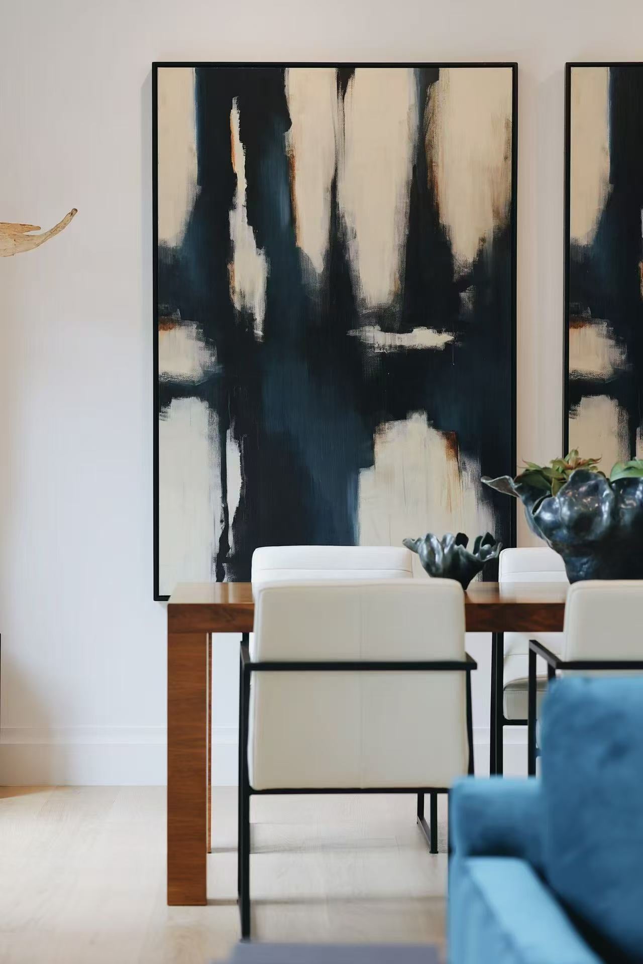 Abstract artwork, console table, and blue sofa detail