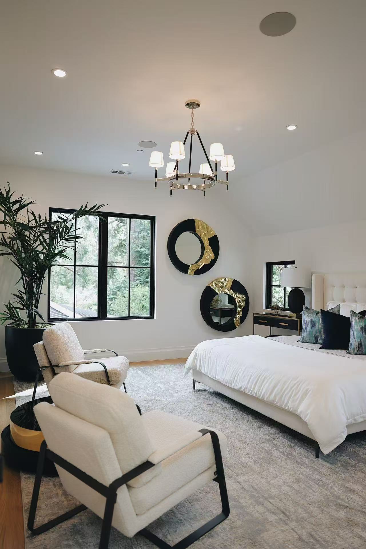 Bedroom view with lounge chair, rug, chandelier, and soft neutral palette