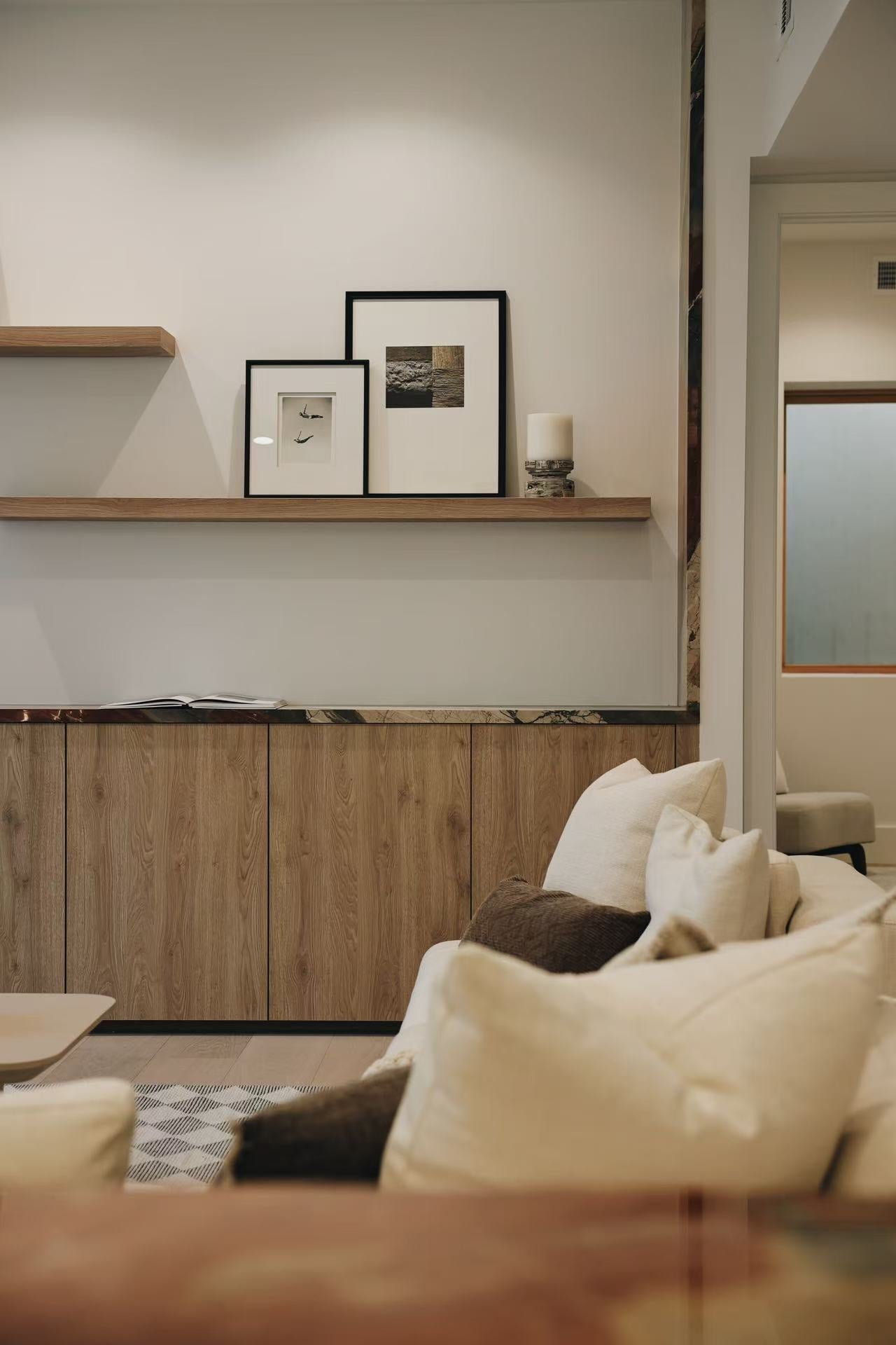 Soft furnished living area with built-in shelving and neutral seating