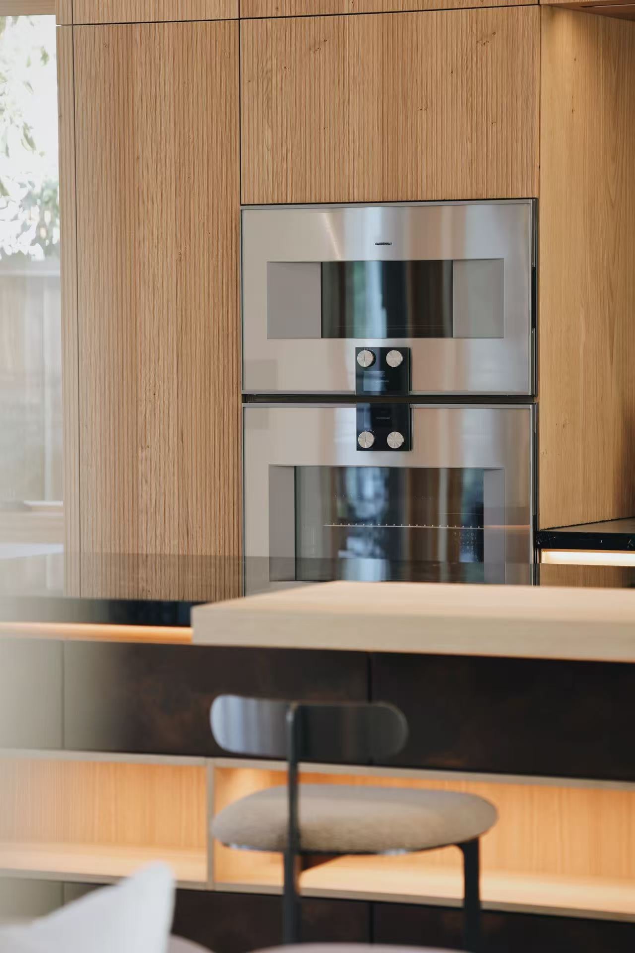 Close view of built-in kitchen appliance wall and island edge
