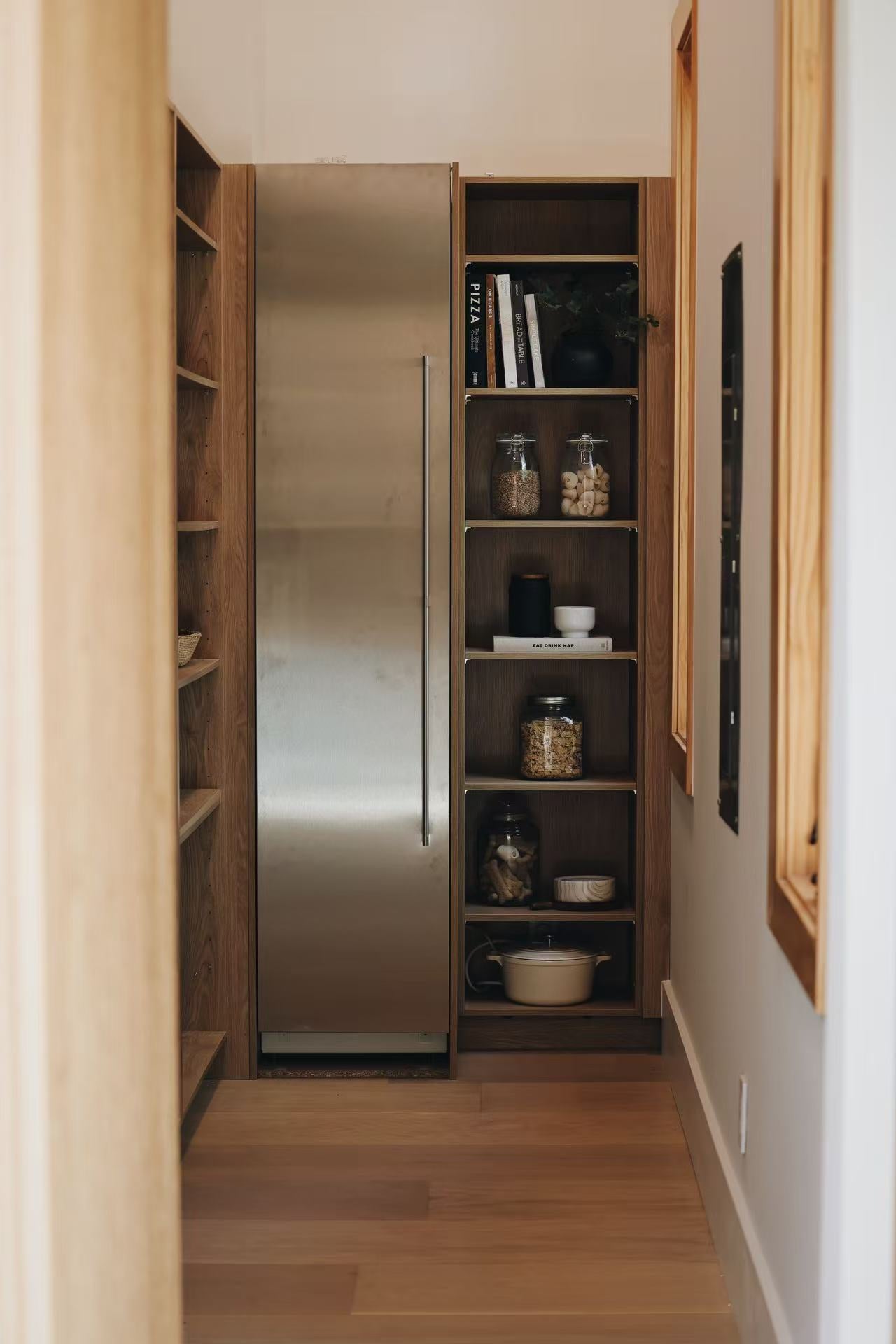 Narrow hallway with integrated timber shelving and appliance wall
