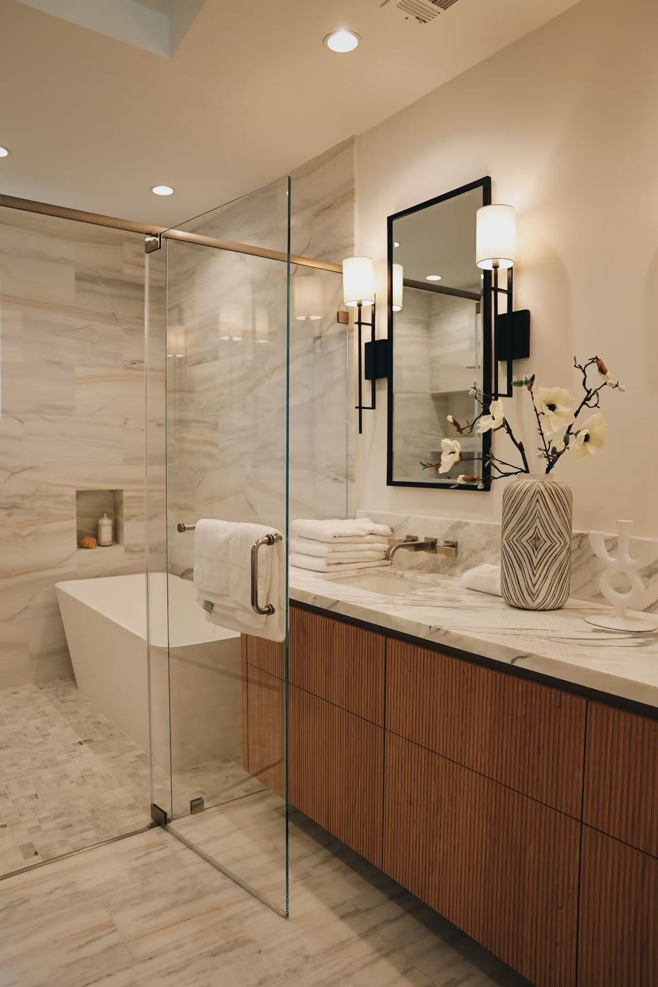 Bathroom vanity with timber cabinets, mirror, glass shower, and stone surfaces