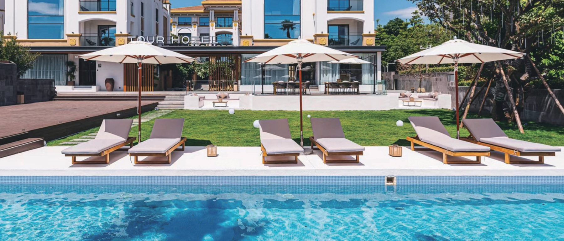Teak sun loungers along a resort pool