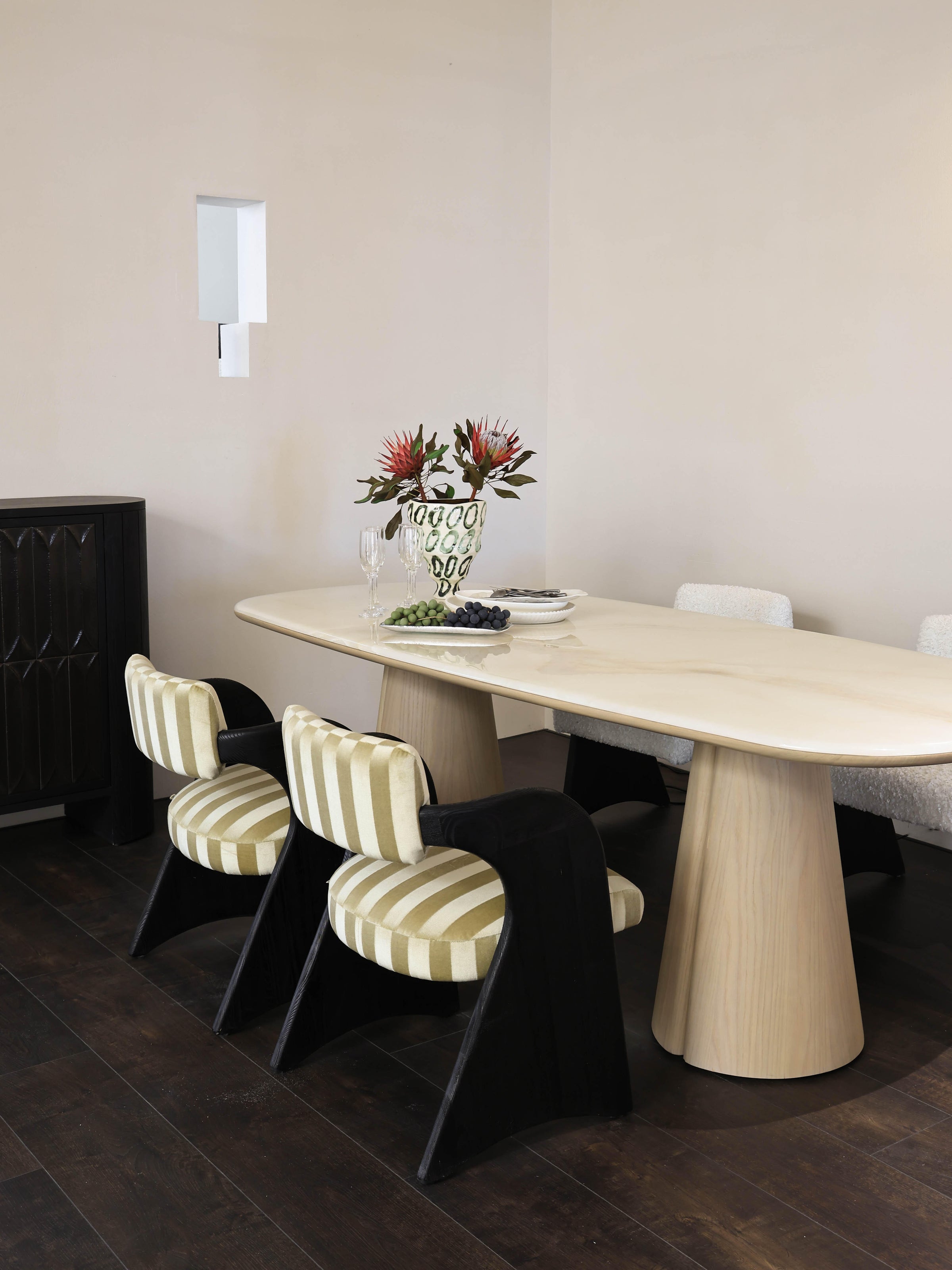 Yusol sculptural dining room with striped chairs and soft wall lighting