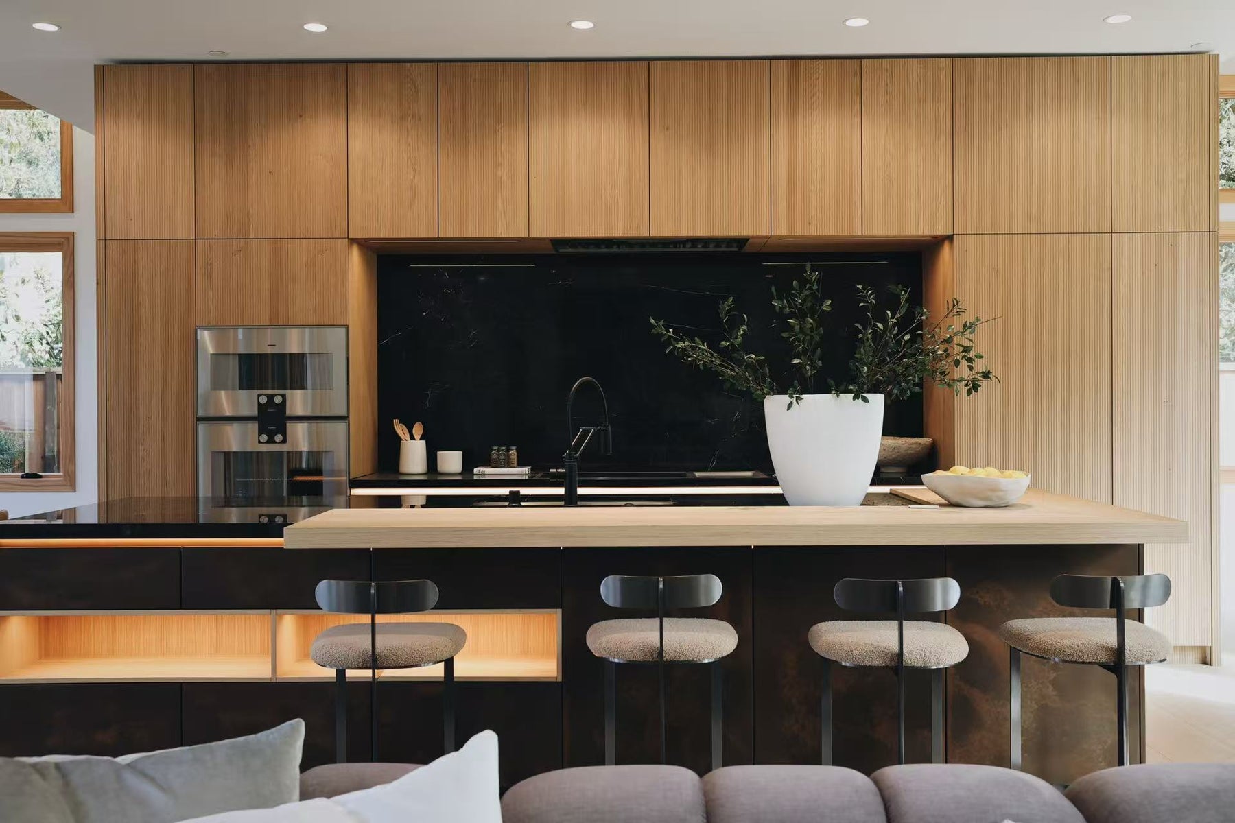 Wide view of the San Jose kitchen with timber cabinetry, island, and black stone backsplash