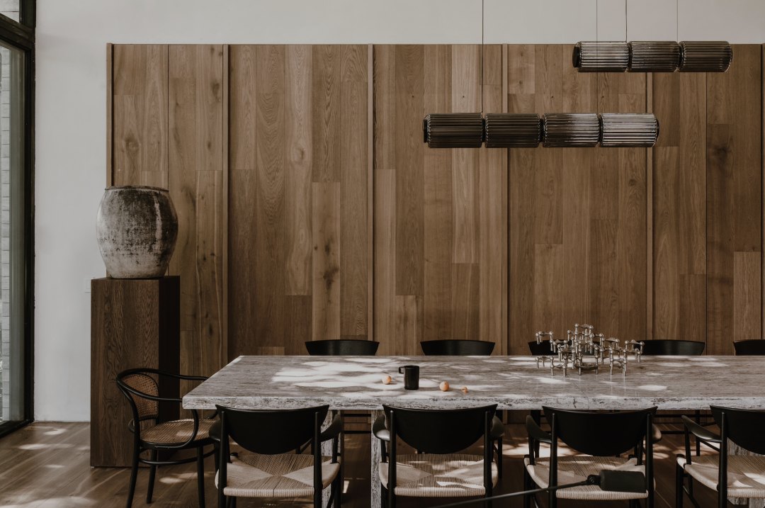 Dining room with a long table under sculptural lighting
