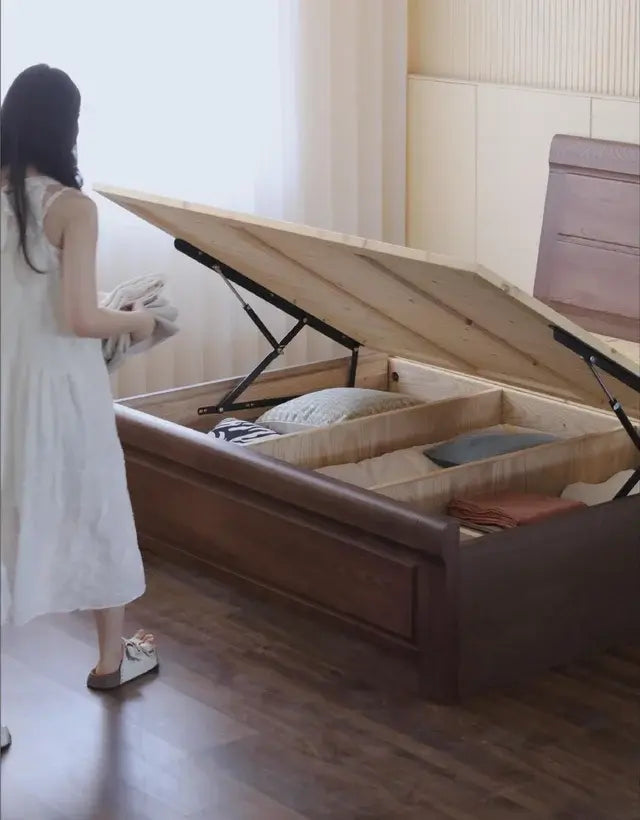 Lift-up storage bed opened to show divided under-bed storage