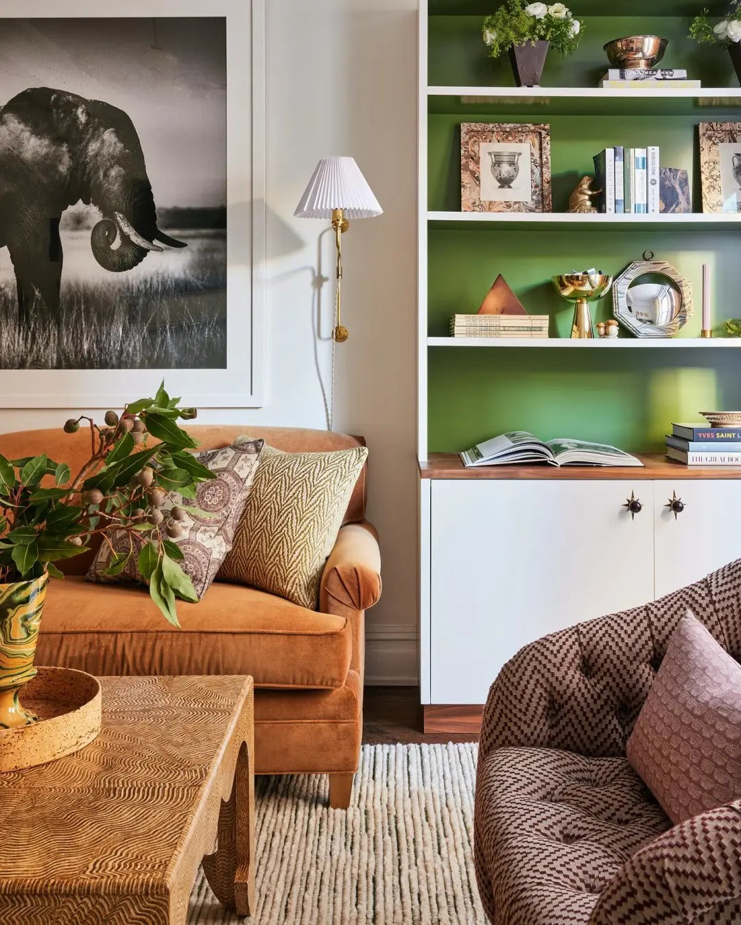 A small sofa moment gains impact through art, pillows, and plants.