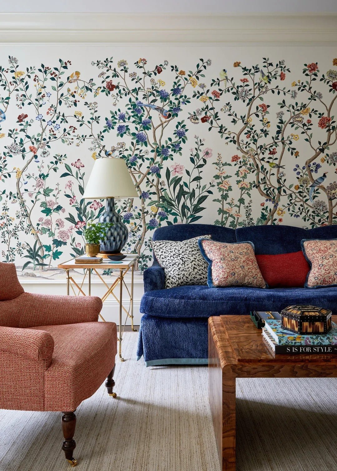 Floral wallpaper and saturated upholstery bring a refined, artful mood.
