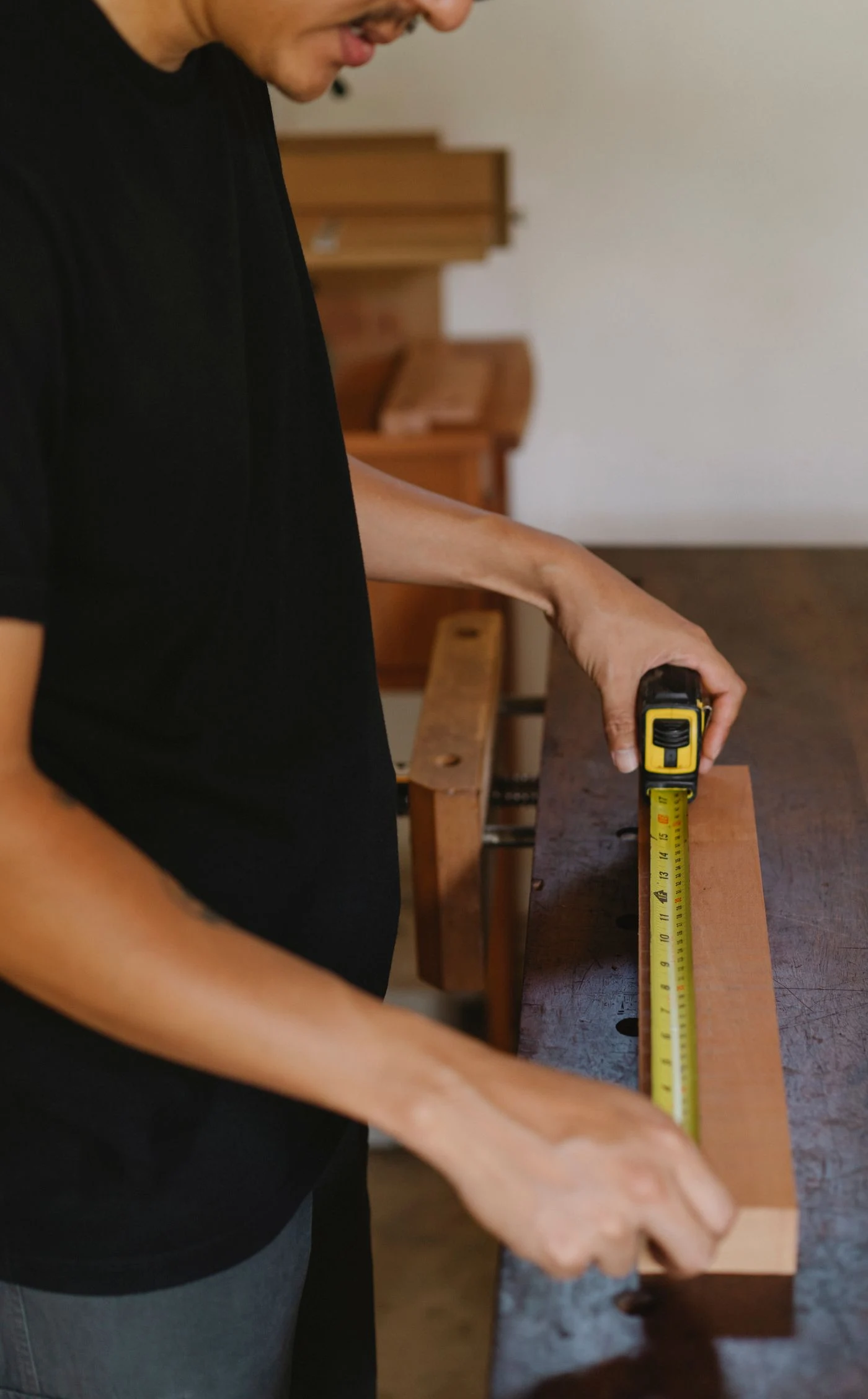 A workshop tape measure checking a timber component
