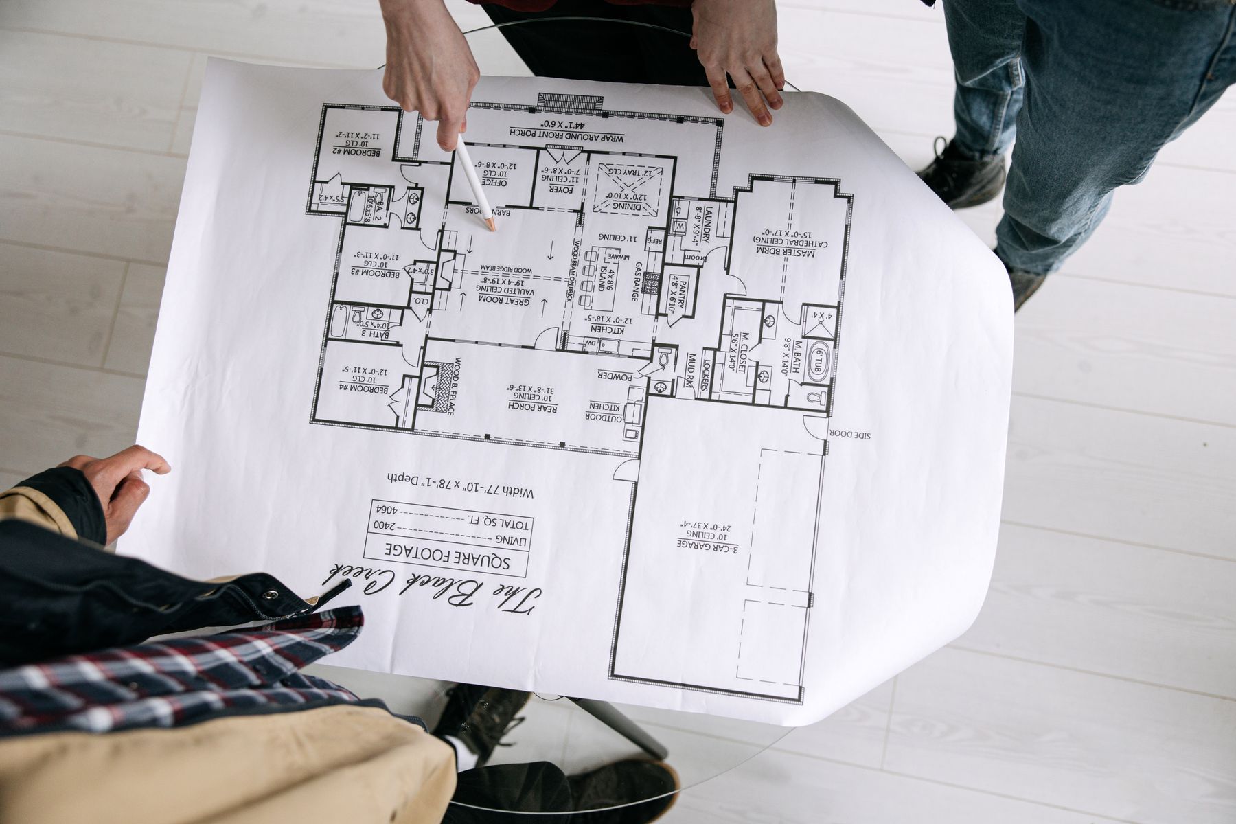 Two architects reviewing a floor plan and wood finish samples together