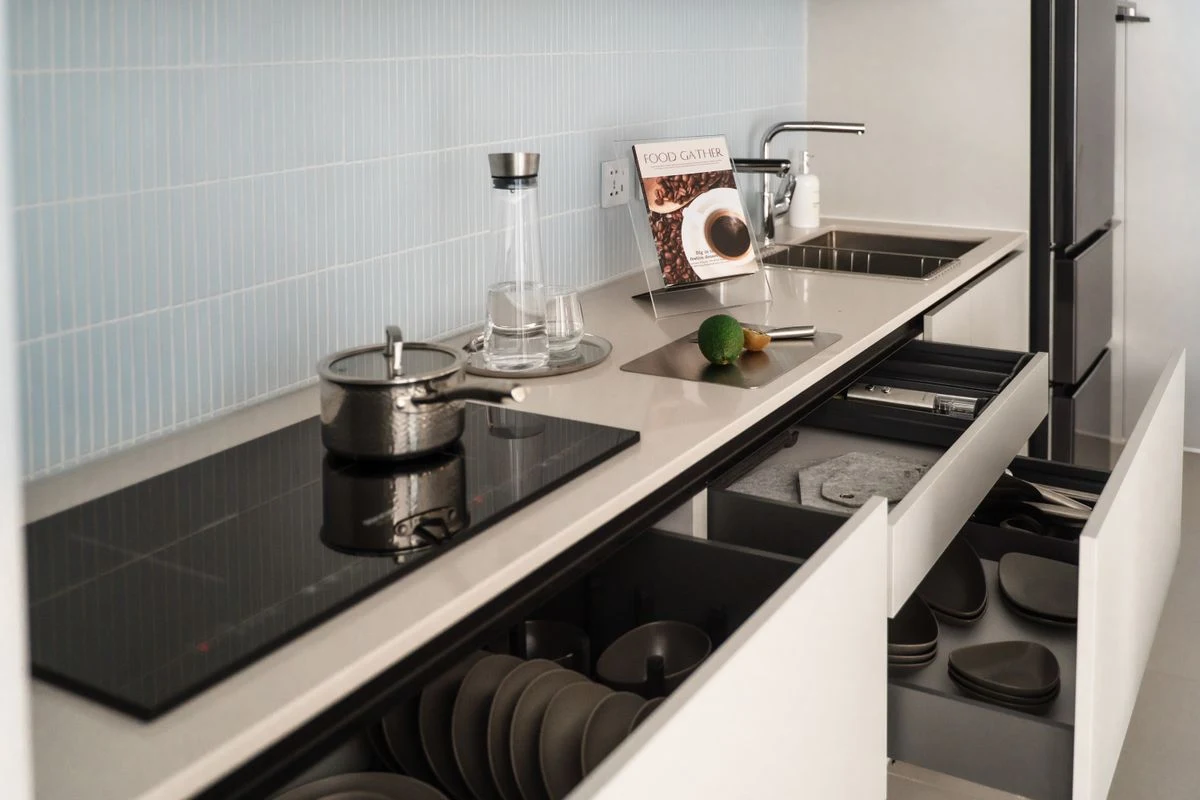 Kitchen base cabinets with open drawers, organised dishes and selected internal fittings