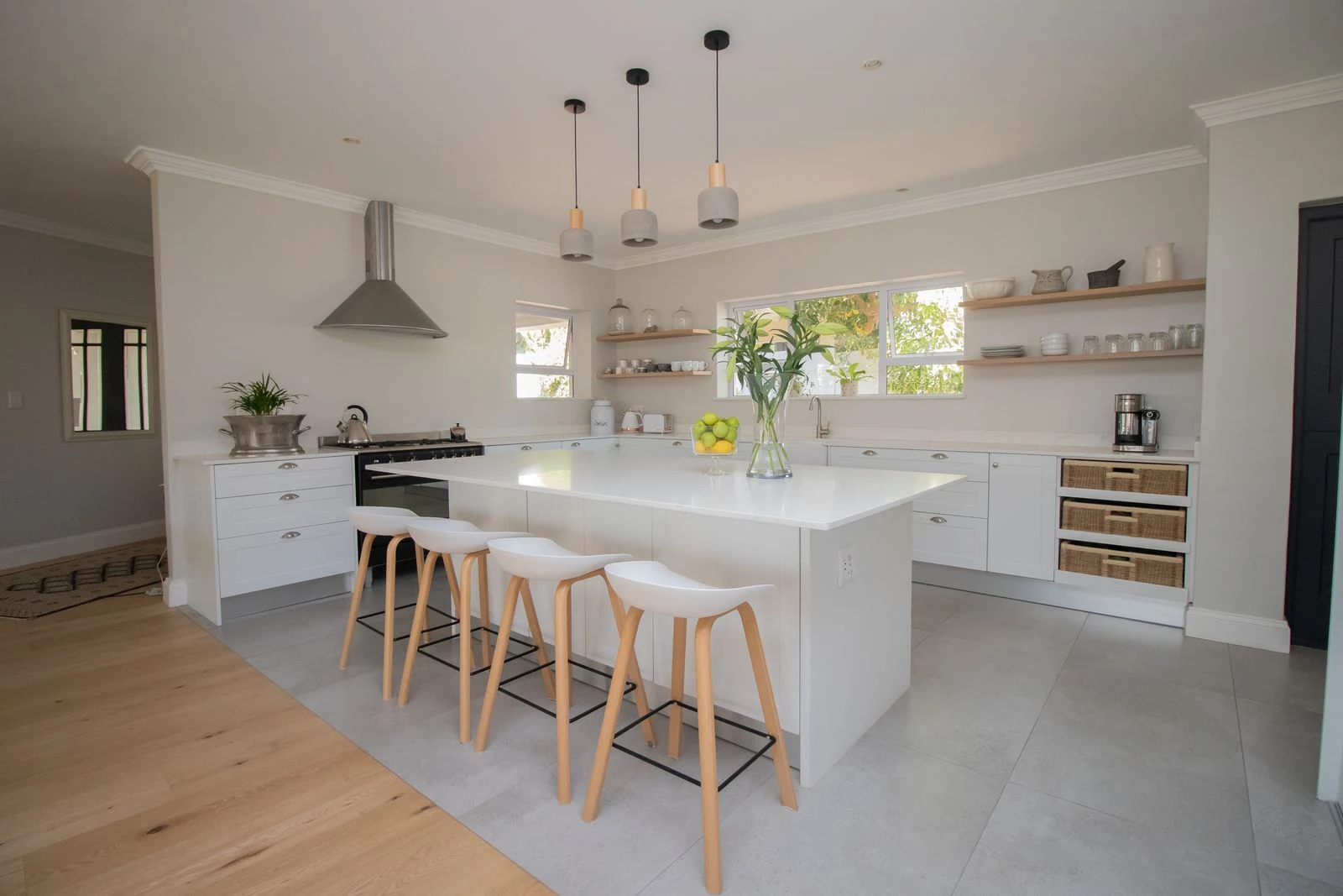White kitchen island with a finished end panel and matching cabinetry plinths