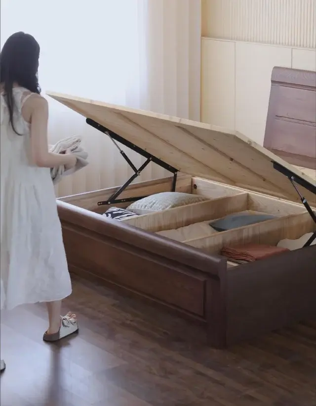 Lift-up storage bed opened to show divided under-bed storage