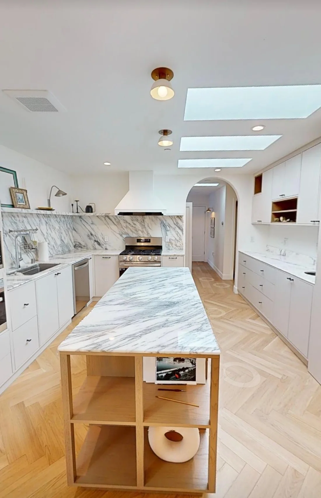The finished kitchen seen down the length of the marble-topped oak island