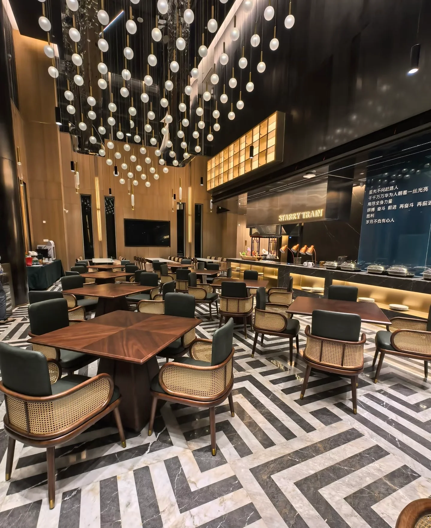 Restaurant dining area with timber tables, cane-backed upholstered chairs and pendant lighting