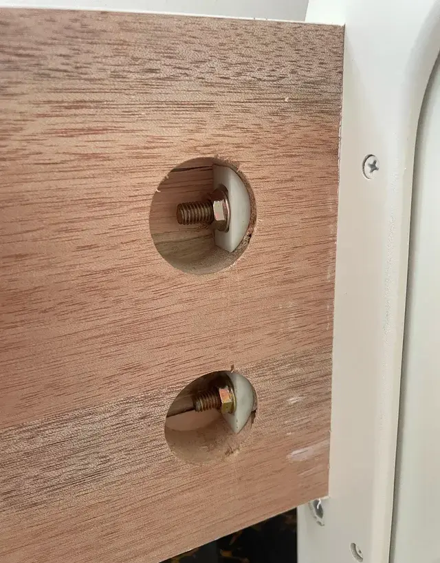 Close-up of bed frame board with half-moon screw connectors
