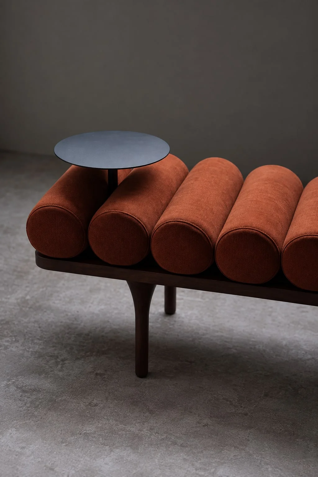 Bench with rolled upholstered cushions and an integrated side table