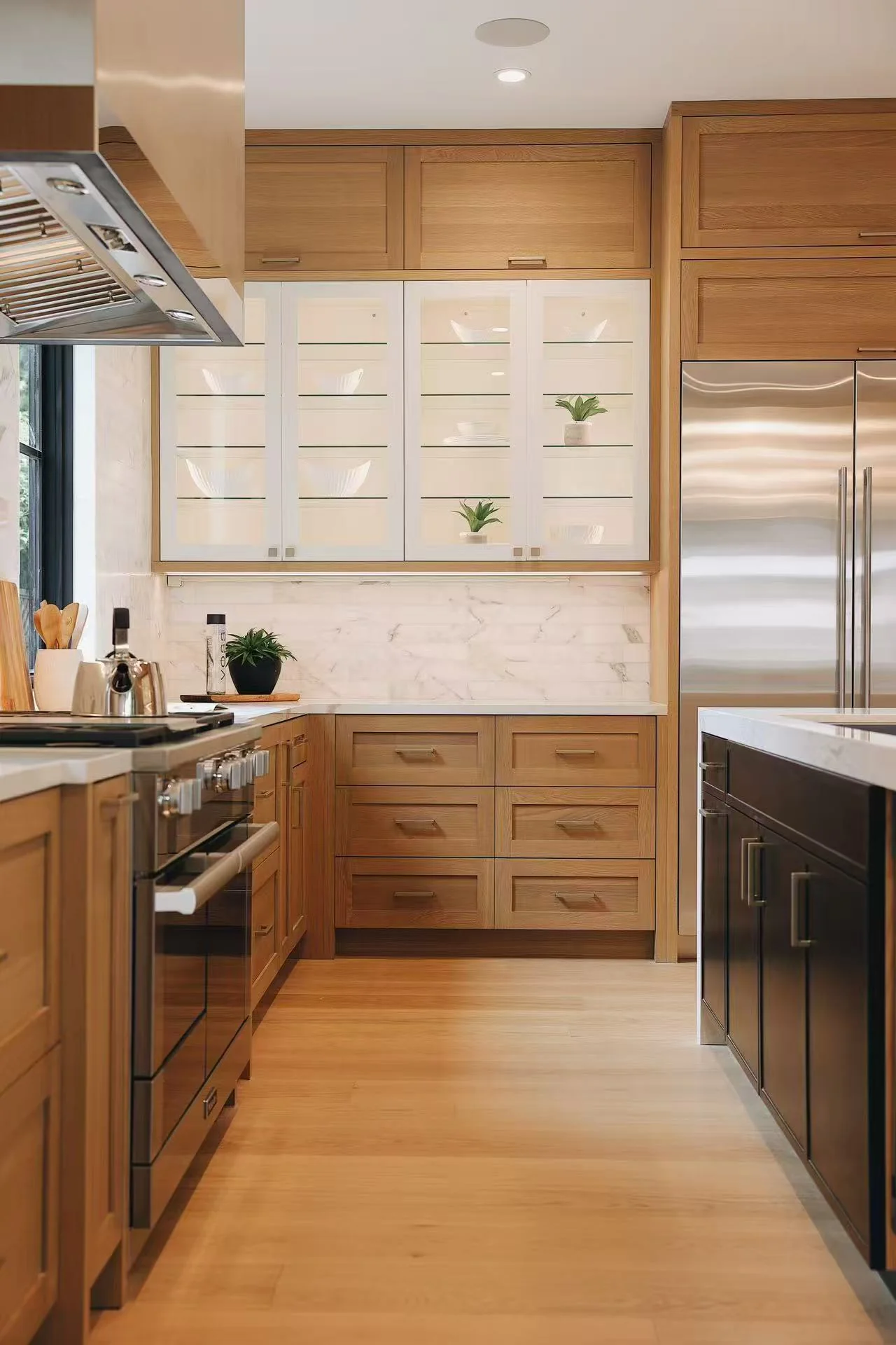 Galley kitchen view with timber cabinetry, range, and marble-effect backsplash