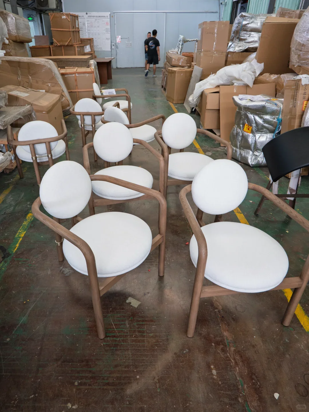 White upholstered timber dining chairs arranged in a workshop